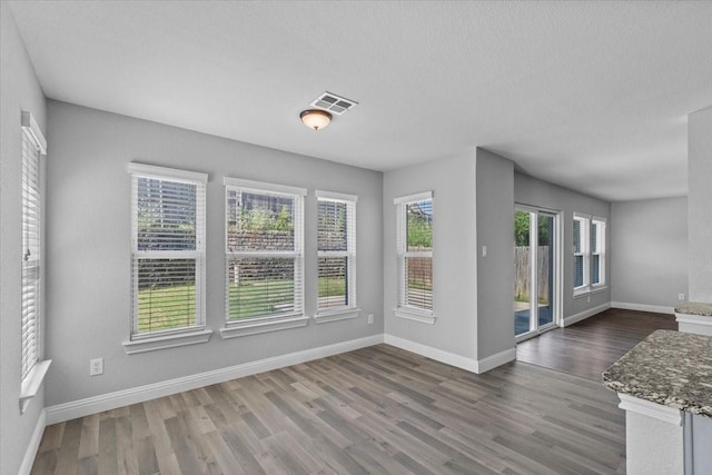 4204 Birch Creek Rd, Fort Worth, TX 76244 - unfurnished dining area featuring wood finished floors, baseboards, and a textured ceiling