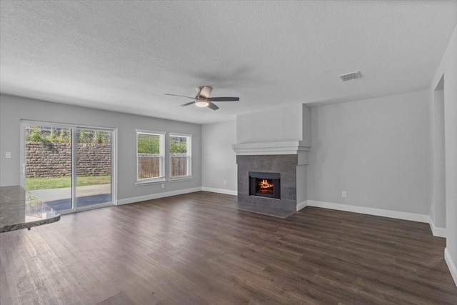 4204 Birch Creek Rd, Fort Worth, TX 76244 - unfurnished living room with ceiling fan, a textured ceiling, dark wood finished floors, a tiled fireplace, and baseboards