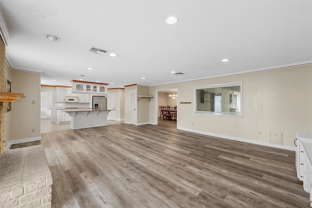 120 Wooded Crest Dr, Woodway, TX 76712 - unfurnished living room featuring ornamental molding, light wood-type flooring, recessed lighting, and baseboards