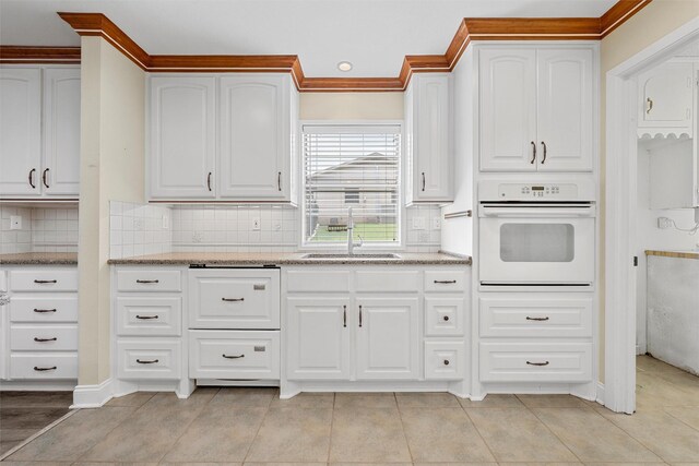 120 Wooded Crest Dr, Woodway, TX 76712 - kitchen featuring white oven, a sink, light stone countertops, backsplash, and white cabinets