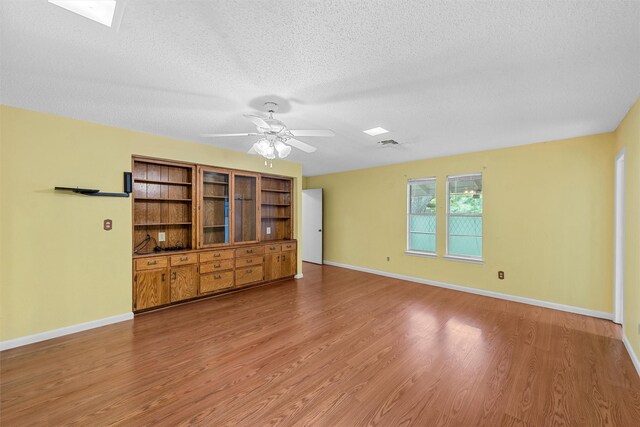 120 Wooded Crest Dr, Woodway, TX 76712 - unfurnished living room featuring light wood-style floors, a textured ceiling, baseboards, and ceiling fan