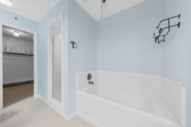 120 Wooded Crest Dr, Woodway, TX 76712 - bathroom with a bath, a walk in closet, a stall shower, baseboards, and tile patterned floors