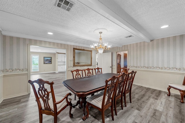 120 Wooded Crest Dr, Woodway, TX 76712 - dining area featuring wainscoting, a textured ceiling, light wood finished floors, wallpapered walls, and a chandelier