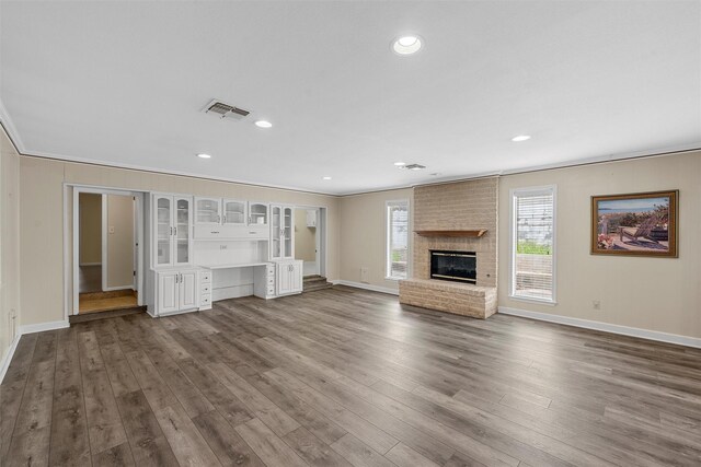 120 Wooded Crest Dr, Woodway, TX 76712 - unfurnished living room featuring baseboards, dark wood-style flooring, ornamental molding, a fireplace, and recessed lighting