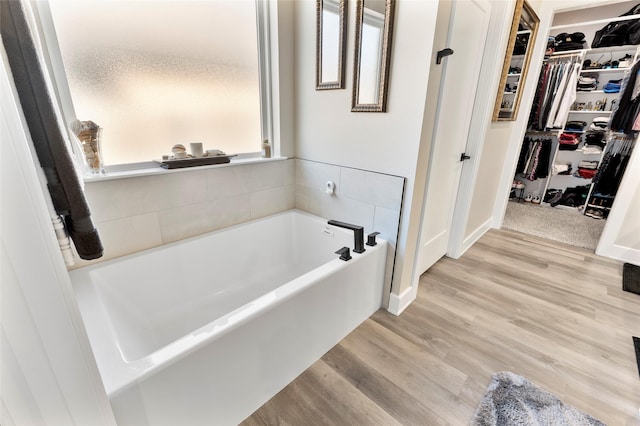 4518 Velta Ln, Abilene, TX 79606 - full bathroom with a bath, a walk in closet, and wood finished floors