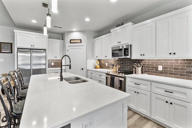 4518 Velta Ln, Abilene, TX 79606 - kitchen featuring a sink, stainless steel appliances, an island with sink, decorative backsplash, and a breakfast bar