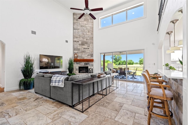 7305 Kingsbarns, The Colony, TX 75056 - living area with stone tile flooring, a towering ceiling, a stone fireplace, and plenty of natural light