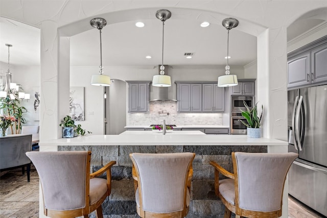 7305 Kingsbarns, The Colony, TX 75056 - kitchen featuring stainless steel appliances, gray cabinetry, tasteful backsplash, light countertops, and a kitchen breakfast bar