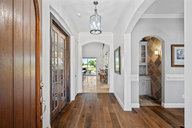 7305 Kingsbarns, The Colony, TX 75056 - foyer with french doors, arched walkways, dark wood finished floors, ornamental molding, and baseboards