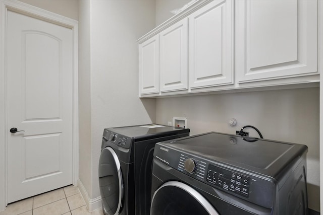 4219 Bal Harbour Ln, Frisco, TX 75033 - washroom featuring washing machine and clothes dryer, cabinet space, light tile patterned floors, and baseboards