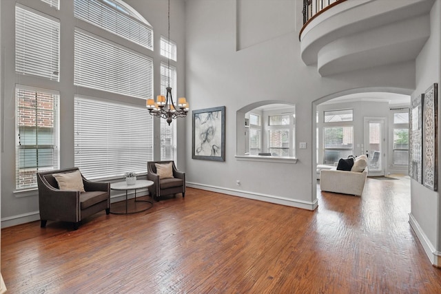 4219 Bal Harbour Ln, Frisco, TX 75033 - living area with wood finished floors, a high ceiling, a chandelier, baseboards, and arched walkways