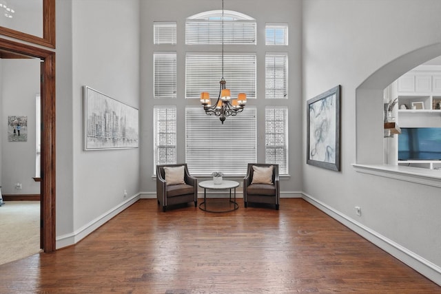 4219 Bal Harbour Ln, Frisco, TX 75033 - living area featuring a chandelier, a towering ceiling, wood finished floors, arched walkways, and baseboards