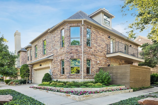 3645 Reagan St, Dallas, TX 75219 - view of side of home with a balcony, brick siding, and an attached garage