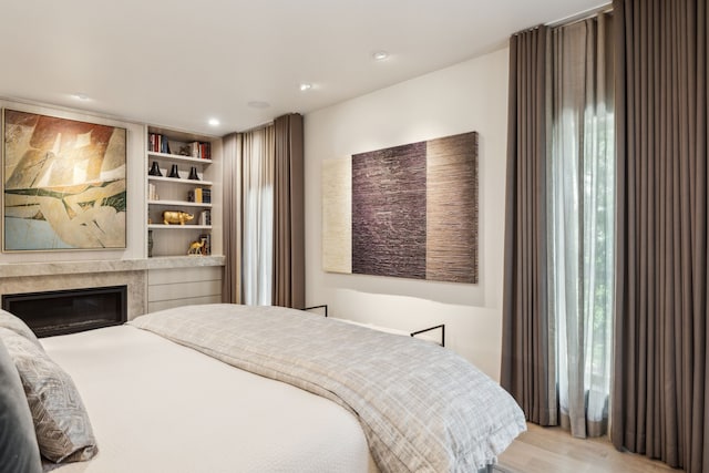 3645 Reagan St, Dallas, TX 75219 - bedroom with wood finished floors, a glass covered fireplace, and recessed lighting