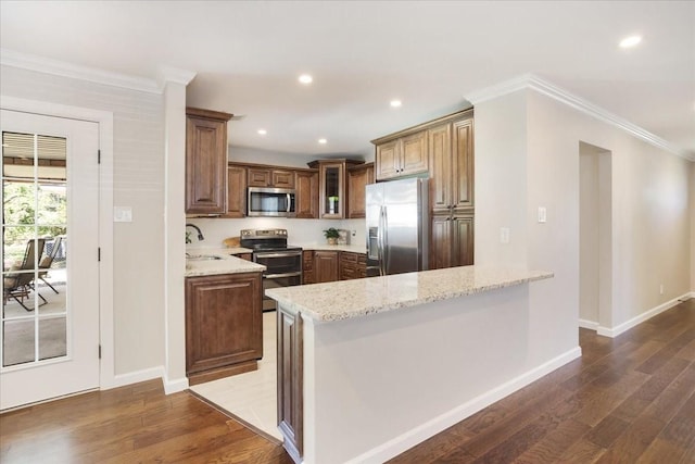 131 S Imperial Dr, Denison, TX 75020 - kitchen featuring appliances with stainless steel finishes, wood finished floors, light stone counters, crown molding, and a sink