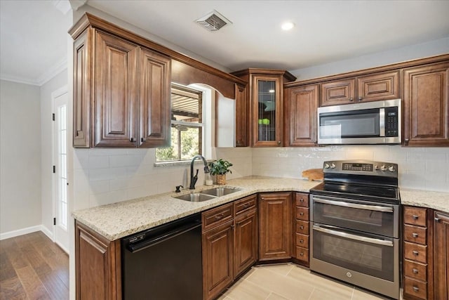 131 S Imperial Dr, Denison, TX 75020 - kitchen with appliances with stainless steel finishes, a sink, crown molding, light stone counters, and backsplash