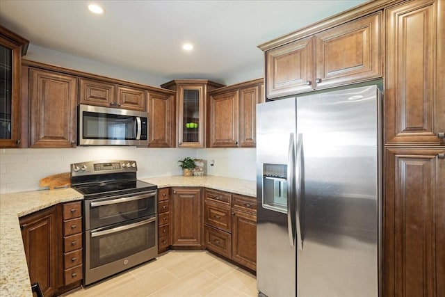 131 S Imperial Dr, Denison, TX 75020 - kitchen with stainless steel appliances, backsplash, light stone counters, glass insert cabinets, and recessed lighting