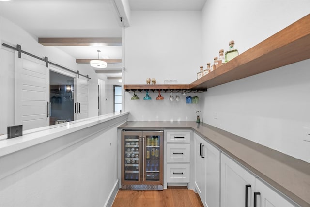 1907 Cedar Bluff Pkwy, Mansfield, TX 76063 - bar featuring wine cooler, a barn door, light wood-style flooring, beamed ceiling, and baseboards