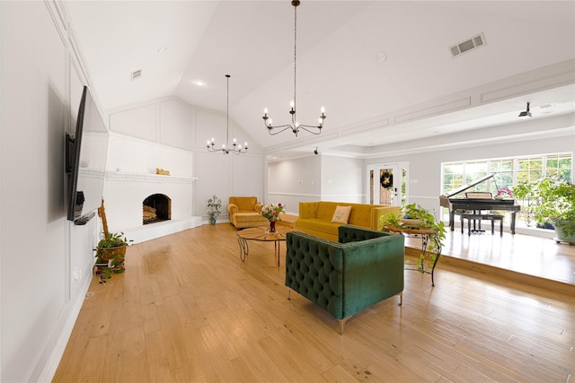 635 E Tripp Rd, Sunnyvale, TX 75182 - living room featuring a chandelier, a fireplace, light wood-type flooring, high vaulted ceiling, and baseboards