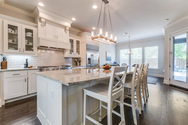 4008 N Cresthaven Rd, Dallas, TX 75209 - kitchen featuring built in refrigerator, crown molding, dark wood finished floors, tasteful backsplash, and white cabinetry
