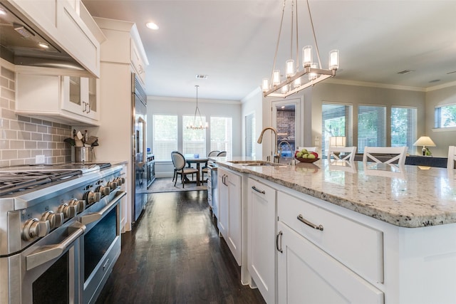4008 N Cresthaven Rd, Dallas, TX 75209 - kitchen with high quality appliances, a chandelier, a sink, dark wood finished floors, and crown molding