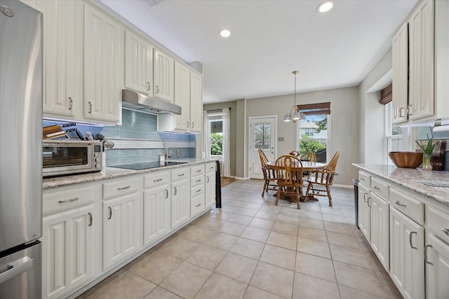 8408 Island Ct, Fort Worth, TX 76137 - kitchen featuring under cabinet range hood, freestanding refrigerator, decorative backsplash, light tile patterned floors, and baseboards