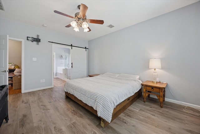 8408 Island Ct, Fort Worth, TX 76137 - bedroom with light wood-style floors, baseboards, and a barn door