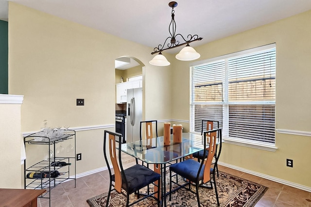4533 Crooked Ridge Dr, The Colony, TX 75056 - dining room with light tile patterned flooring, arched walkways, and baseboards