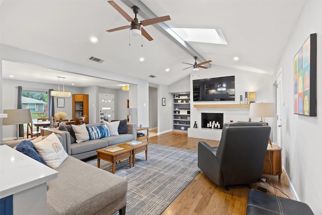 2708 Hunters Creek Dr, Plano, TX 75075 - living area with ceiling fan, wood finished floors, baseboards, a fireplace with raised hearth, and a skylight