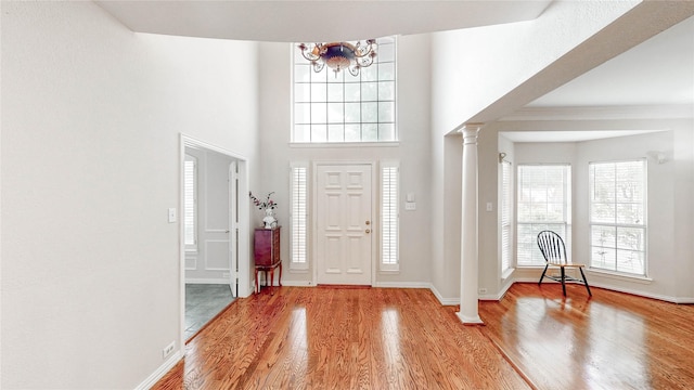 2700 Lake Crest Dr, Flower Mound, TX 75022 - foyer with ornate columns, a chandelier, wood finished floors, baseboards, and a towering ceiling