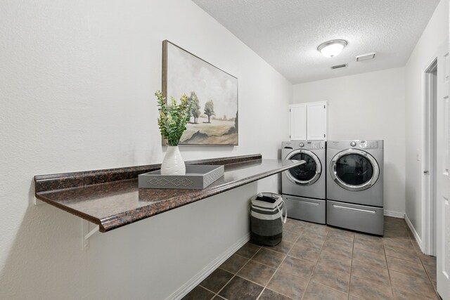 3428 Glade Creek Dr, Hurst, TX 76054 - laundry room featuring independent washer and dryer, a textured ceiling, cabinet space, baseboards, and tile patterned floors