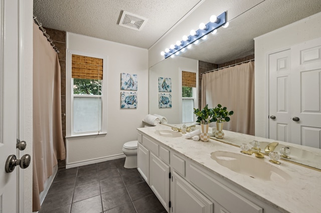 3428 Glade Creek Dr, Hurst, TX 76054 - full bath featuring double vanity, a textured ceiling, baseboards, tile patterned floors, and toilet