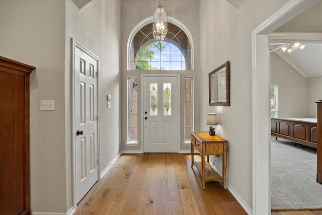 3134 Oak Dr, Rockwall, TX 75032 - foyer with a chandelier, light wood-style floors, baseboards, high vaulted ceiling, and a ceiling fan