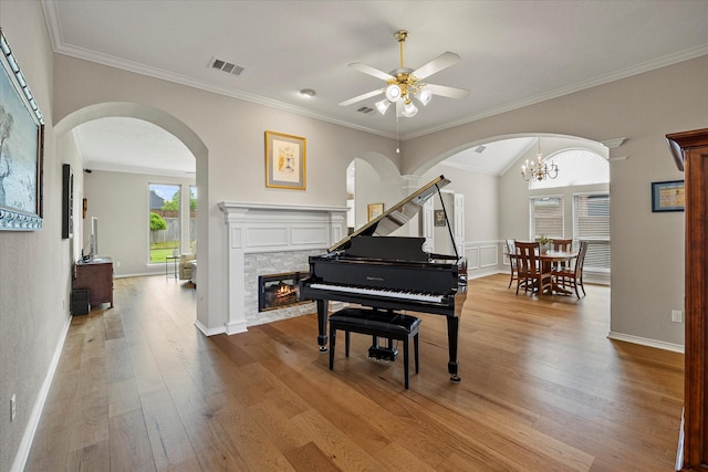 3134 Oak Dr, Rockwall, TX 75032 - living area featuring a ceiling fan, wood finished floors, a fireplace, crown molding, and arched walkways