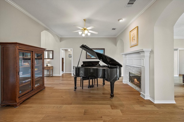 3134 Oak Dr, Rockwall, TX 75032 - sitting room featuring arched walkways, ornamental molding, ceiling fan, light wood-type flooring, and a glass covered fireplace