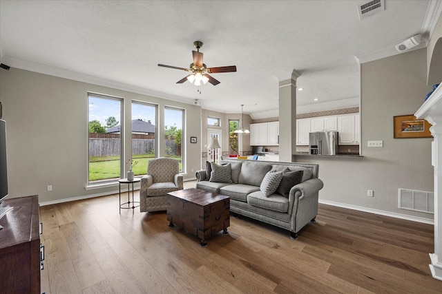 3134 Oak Dr, Rockwall, TX 75032 - living area with ceiling fan, baseboards, crown molding, wood finished floors, and decorative columns