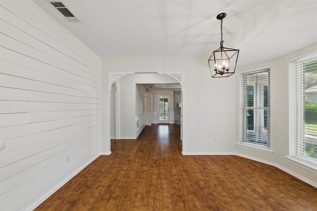 207 Johnston Blvd, Waxahachie, TX 75165 - unfurnished dining area featuring arched walkways, dark wood-style flooring, a chandelier, and baseboards