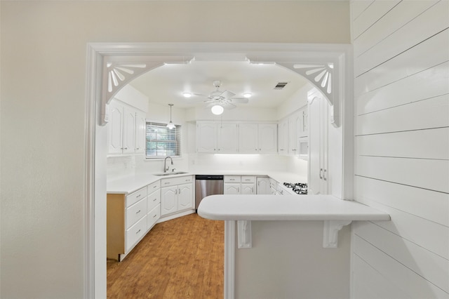 207 Johnston Blvd, Waxahachie, TX 75165 - kitchen with stainless steel dishwasher, a peninsula, white cabinets, a sink, and arched walkways
