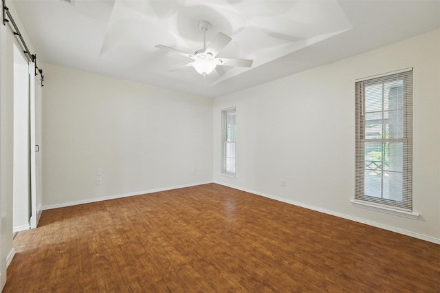 207 Johnston Blvd, Waxahachie, TX 75165 - spare room featuring a barn door, plenty of natural light, and wood finished floors