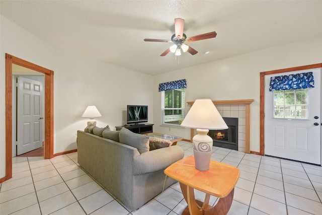 2207 Villanova St, Arlington, TX 76018 - living room featuring light tile patterned floors, ceiling fan, a tiled fireplace, and baseboards