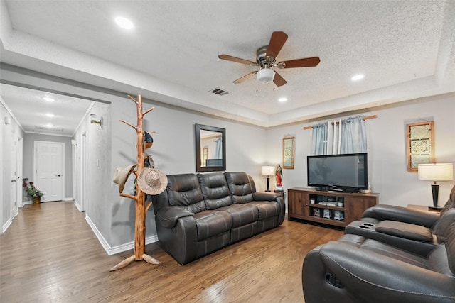 11514 Oakfield Dr, Balch Springs, TX 75180 - living area featuring a raised ceiling, a ceiling fan, light wood-style flooring, a textured ceiling, and recessed lighting
