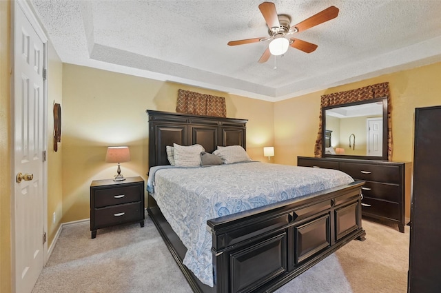 11514 Oakfield Dr, Balch Springs, TX 75180 - bedroom with light colored carpet, a textured ceiling, a ceiling fan, baseboards, and a tray ceiling