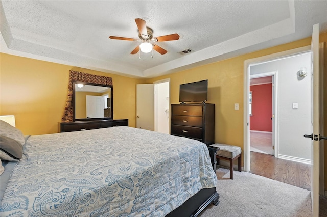 11514 Oakfield Dr, Balch Springs, TX 75180 - carpeted bedroom featuring a raised ceiling, a textured ceiling, and a ceiling fan