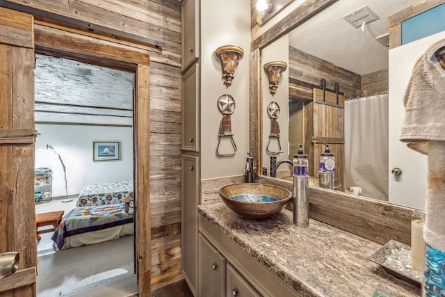 106 Hillcroft Dr, Weatherford, TX 76087 - bathroom featuring wooden walls, vanity, ensuite bathroom, a textured ceiling, and a shower with curtain