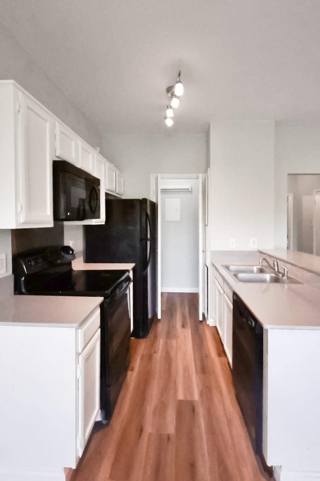 7340 Skillman St Unit 1109, Dallas, TX 75231 - kitchen with black appliances, a sink, a peninsula, and white cabinets