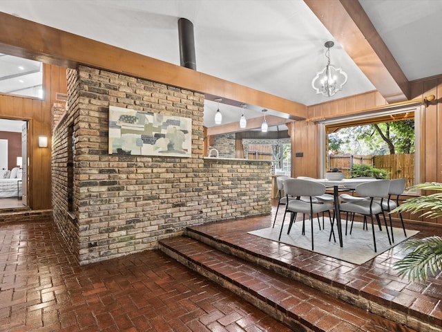 5217 Blue Valley Ct, Fort Worth, TX 76112 - dining room featuring wooden walls, a chandelier, and brick floors
