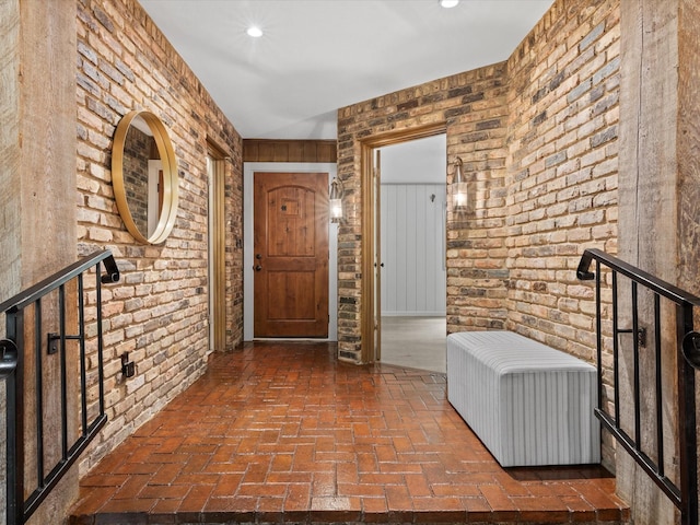 5217 Blue Valley Ct, Fort Worth, TX 76112 - foyer entrance featuring brick floors, brick wall, and recessed lighting