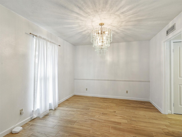 3146 Oak Hill Rd, Carrollton, TX 75007 - empty room with a chandelier, light wood-style floors, and baseboards