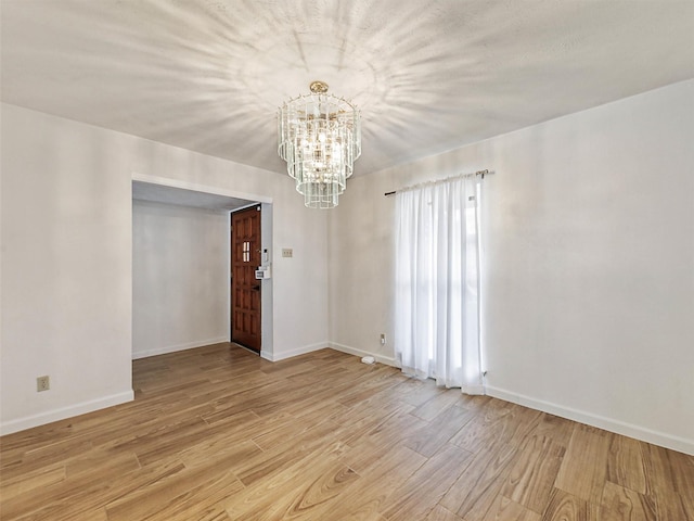 3146 Oak Hill Rd, Carrollton, TX 75007 - spare room with a chandelier, light wood-style floors, and baseboards