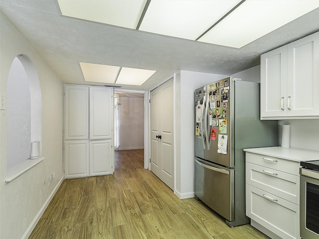 3146 Oak Hill Rd, Carrollton, TX 75007 - kitchen featuring light wood-style flooring, stove, white cabinets, and baseboards
